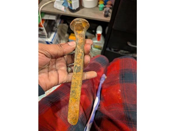 A rusted railroad spike found magnet fishing