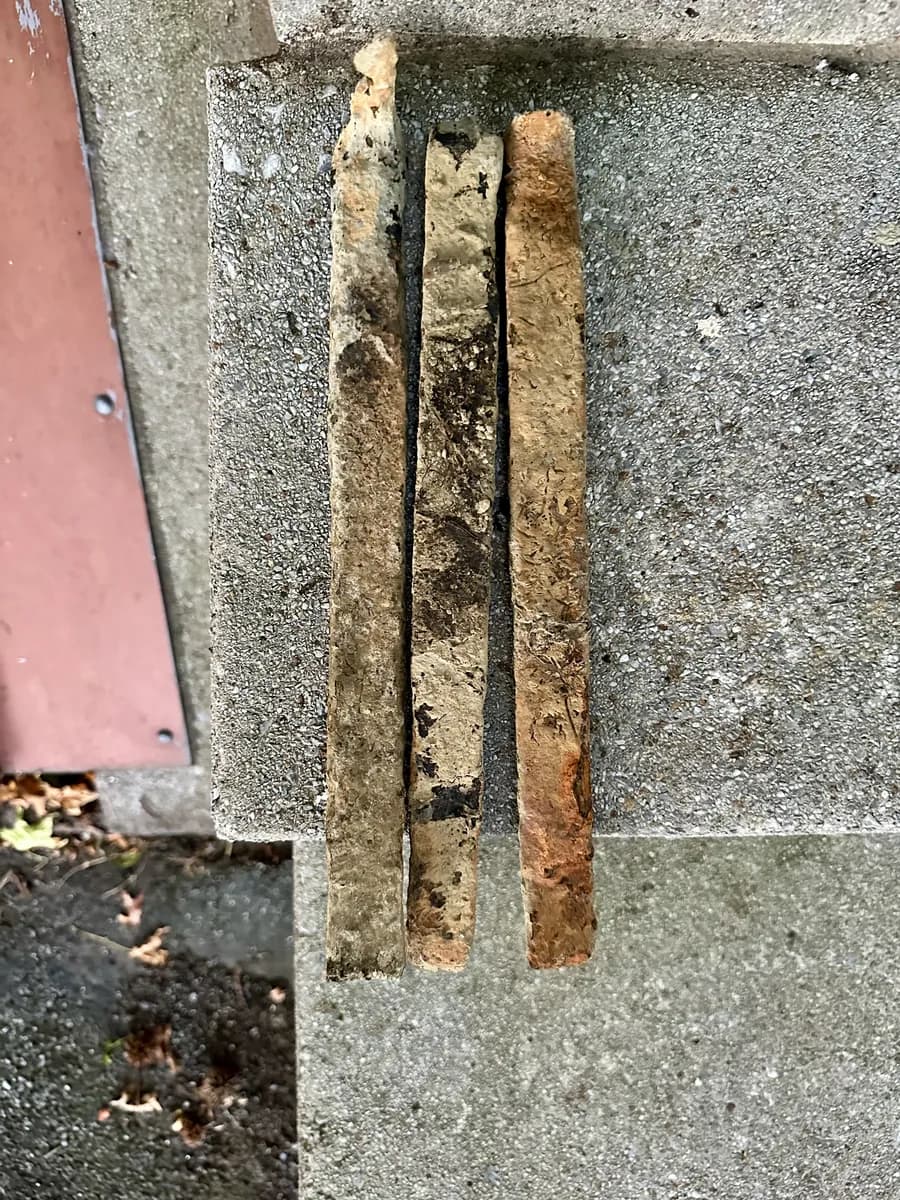 Three square hand-forged iron spikes that once held Union Canal stones together, recovered while magnet fishing in Myerstown, Pennsylvania